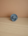 Frigg Moon Rubber Ocean View pacifier on a beige surface.