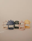 Five mushie No-Drop Sensory Teether toys in pastel sun and cloud shapes are displayed against a beige background, offering soothing relief for babies as gentle, easy-to-hold silicone sensory teethers.