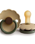 Two FRIGG Daisy Natural Rubber Pacifiers in beige and olive green, with scalloped edges, shown from front and side angles. Features FRIGG branding on the ring and latex nipples for comfort. Limited Edition 2-pack.