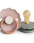 The FRIGG Daisy Natural Rubber Pacifier 2-Pack includes two daisy-shaped pacifiers, one pink and tan with a white button, and one green and gray with a yellow rubber nipple—combining comfort and style for your baby.