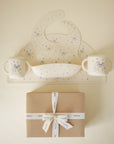 The mushie Bluey Gift Set includes a silicone bib and two handled cups with animal designs, all arranged above a brown gift box tied with a white ribbon—ideal for stylish baby mealtime.