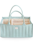 The mushie Diaper Caddy in Roman Green features double handles and interior compartments, making it a stylish and practical organizer, shown against a white background.