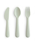 The mushie Dinnerware Cutlery Set is a non-toxic, dishwasher-safe set with a light gray knife, spoon, and fork displayed side by side on a white background.