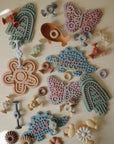 Mushie Silicone Sensory Toy: bird, butterfly & flower shapes for fine motor play.