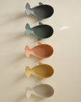 Mushie Whale Bath Stackers: five colorful, whale-shaped toys stacked on a light background.