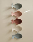 Five pastel Whale Bath Stackers by Mushie stacked vertically on a light surface.