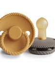 The Mushie FRIGG Rope Natural Rubber Pacifier 2-Pack features two pacifiers in golden yellow and gray, both with rope-like edges and natural rubber latex nipples, designed for little ones.