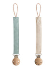 Mushie Linen Pacifier Clip 2-Pack in light blue and beige with wooden clasps, side by side.