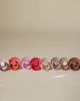 Two pastel FRIGG Daisy Natural Rubber Pacifiers on a neutral background.