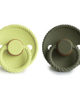 The Mushie FRIGG Rope Natural Rubber Pacifier 2-Pack includes two round pacifiers with textured rope-like edges and rings—one light green, one dark green—each featuring a natural rubber latex nipple. Perfect essentials for your baby.