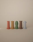Five mushie Silicone Animal Finger Puppets in red, yellow, green, brown, and light blue with cute animal faces encourage fun and fine motor skill development. Perfect as kids' bath toys; displayed on a neutral background.