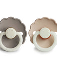 The FRIGG Daisy Night Natural Rubber Pacifier 2-Pack by FRIGG features two pacifiers—one gray, one beige—with scalloped edges, white rings, and natural rubber latex nipples, shown side by side on a white background.