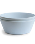 Two simple Round Dinnerware Bowls by mushie in light blue are stacked together against a plain white background.