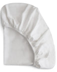 The mushie Stretchy Crib Sheet is shown partially folded on a plain white background, featuring elastic edges for a snug fit.