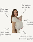 A woman carries her baby in the mushie Baby Wrap—a white, organic cotton wrap that’s breathable, machine washable, one size fits most, holds babies 8–33 lbs, and stores in its built-in pocket for comfortable baby wearing.