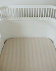 Mushie Extra Soft Muslin Crib Sheet on a white crib in a clean, minimal nursery setting.