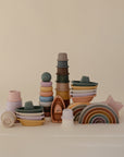 The mushie Stacking Rings Toy, made of non-toxic pastel-colored silicone, features stackable rings ideal for babies and is displayed on a plain beige background.