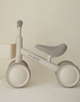 Mushie Mini Toddler Bike in beige & cream with basket—ideal first bike for toddlers.