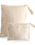 Two mushie Water Resistant Wet Bags in Sun color, featuring small yellow sun patterns and fabric wrist straps, are shown side by side. Each wet bag includes a front zipper pocket and comes in two sizes for convenient diaper bag storage.