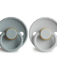 The Mushie FRIGG Rope Natural Rubber Pacifier 2-Pack includes two light gray pacifiers with round shields, textured rope-like edges, circular handles, ventilation holes, and natural rubber latex nipples. "FRIGG" is embossed on the bottom.