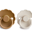 The FRIGG Daisy Natural Rubber Pacifier 2-Pack by FRIGG includes light brown and off-white daisy-shaped pacifiers, each with a round shield, handle, and soothing natural rubber latex nipple, displayed side by side on a white background.
