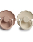The FRIGG Daisy Silicone Pacifier 2-Pack by FRIGG features light brown and cream pacifiers, each with a daisy-shaped shield, round handle, and a medical-grade silicone nipple for your baby’s comfort.