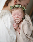 Lifestyle image of a baby swaddled in organic cotton swaddle in Caramel Polka Dot