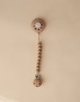 The FRIGG Andersen Fairytale Silicone Pacifier 2-Pack by FRIGG is displayed vertically on a beige background.