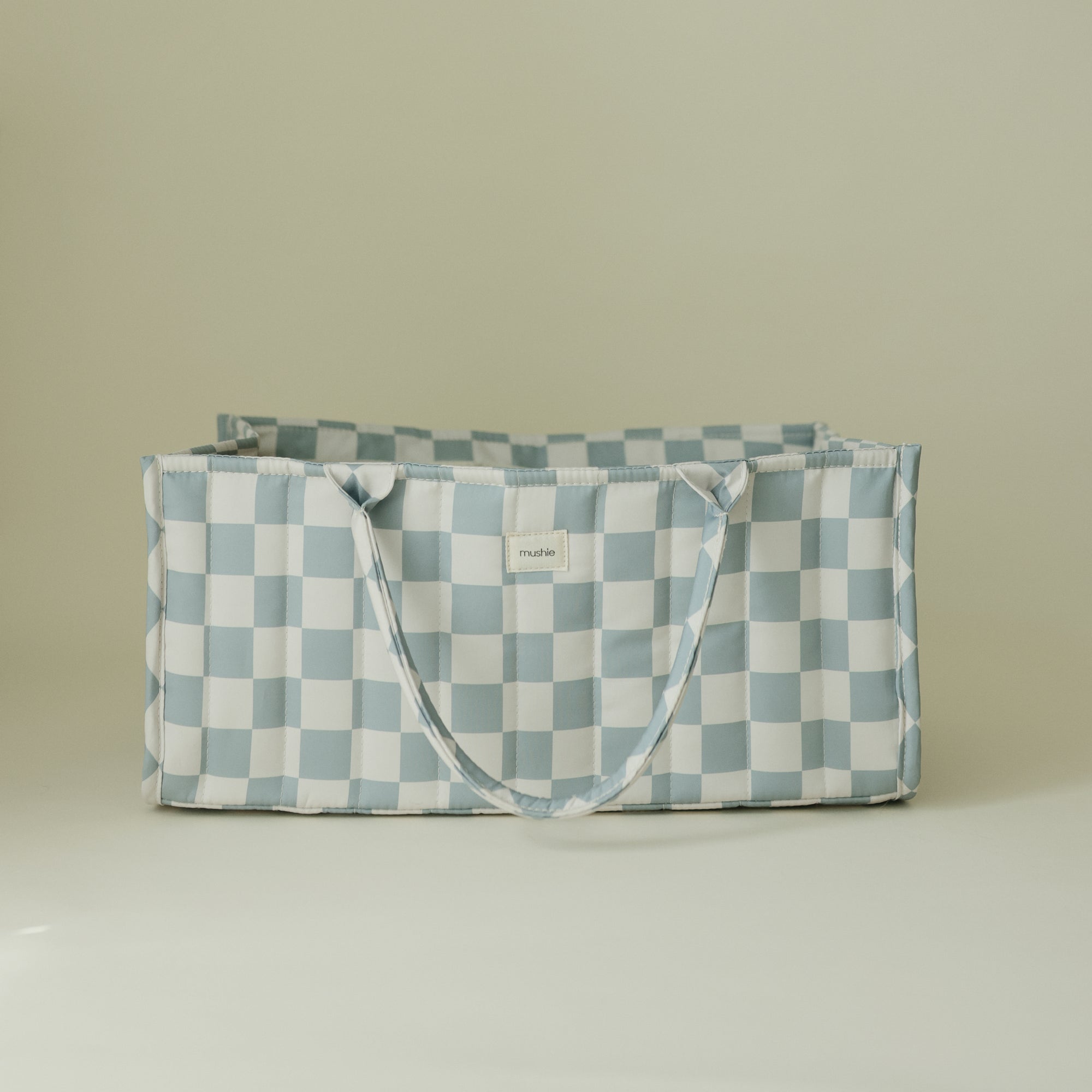 Mushie Diaper Caddy—light blue &amp; white checkered tote bag with handles on plain background.