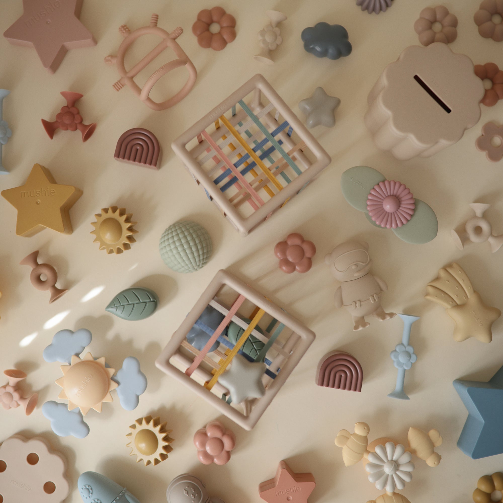 Mushie Elastic Shape Sorter for tactile play and fine motor skills in pastel colors.