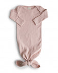 Blush-colored organic cotton Ribbed Knotted Baby Gown with a knotted hem.