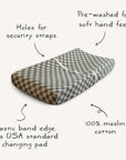 The mushie Extra Soft Muslin Changing Pad Cover features a gray and white checkered design, pre-washed for softness, with security strap holes and an elastic edge. Fits USA standard pads for a secure, comfortable fit.