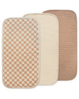 Three overlapping Mushie Changing Pad Liners in Check Combo color.