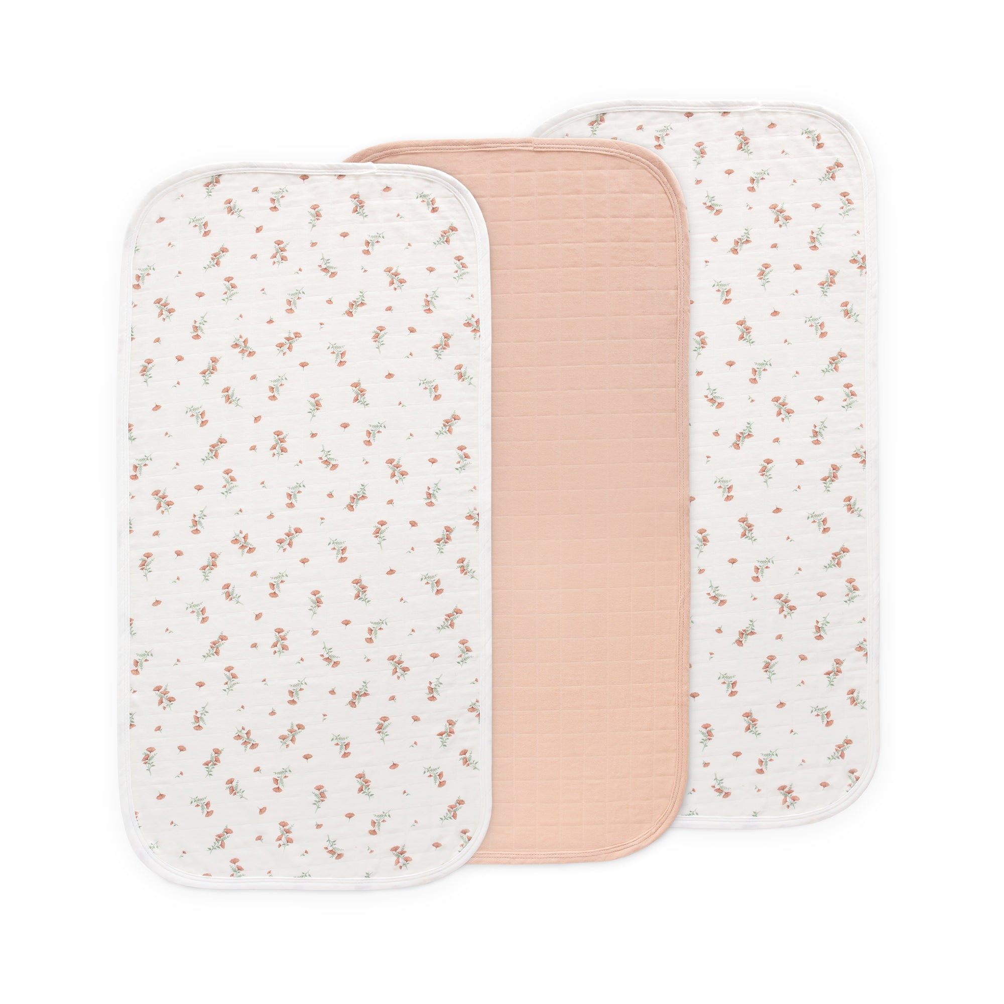 Three Mushie Changing Pad Liners: two floral, one solid light pink, all organic cotton.