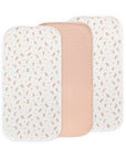 Three Mushie Changing Pad Liners: two floral, one solid light pink, all organic cotton.