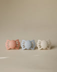 FRIGG Lucky Symmetrical Silicone Pacifier 2-Pack for 6-18 months in pink, blue, and beige.