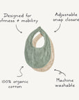 The mushie Muslin Bib set includes two teething bibs, one green and one beige, designed for softness and mobility with an adjustable snap closure. Made from 100% organic cotton muslin, they're machine washable for easy care.