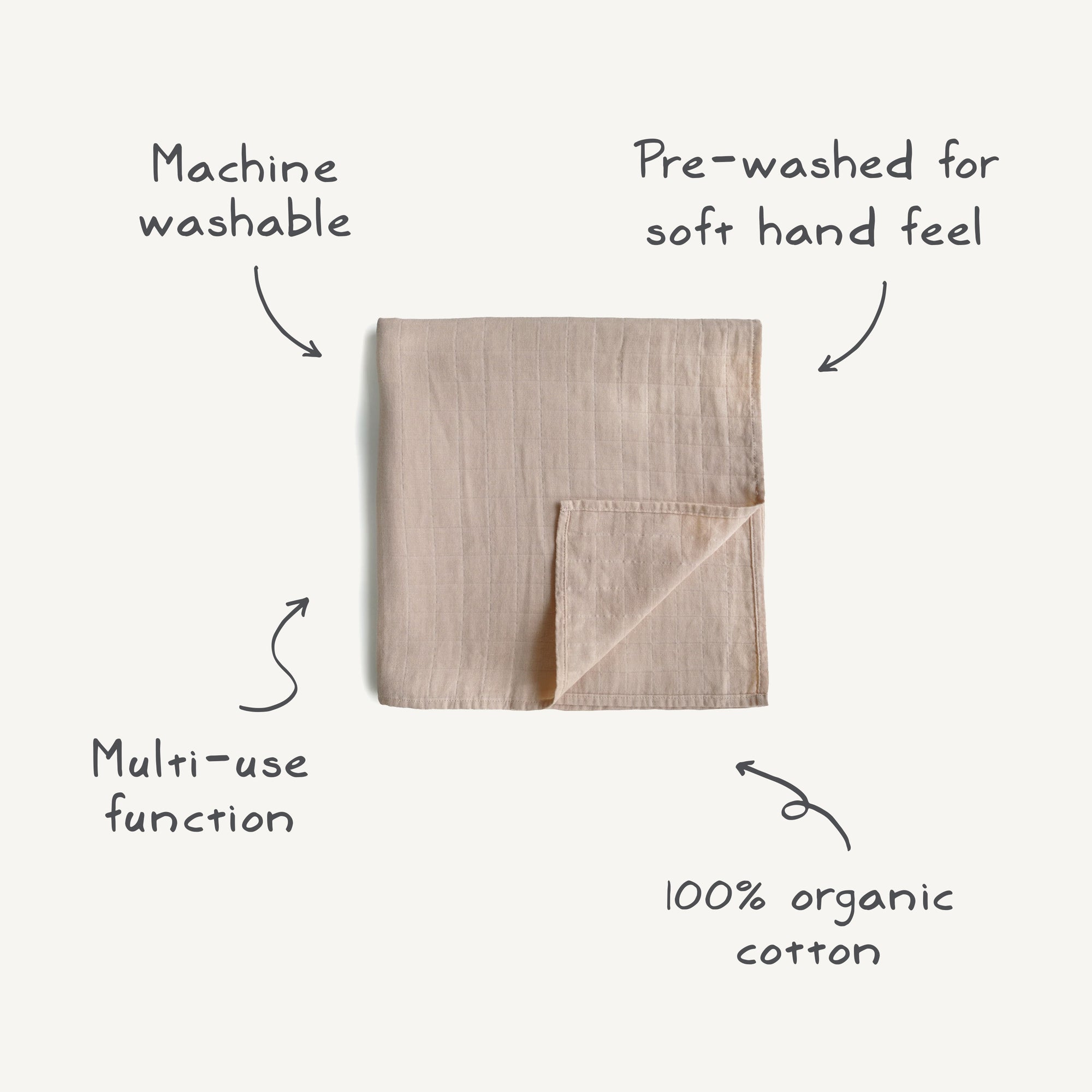 The mushie Organic Cotton Muslin Swaddle Blanket, shown in beige with a folded corner, is 100% organic cotton, pre-washed for softness, machine washable, and designed for multiple uses as a swaddle or baby blanket.