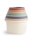 Mushie Stacking Cups Toy in pastel colors, stacked largest to smallest on white background.
