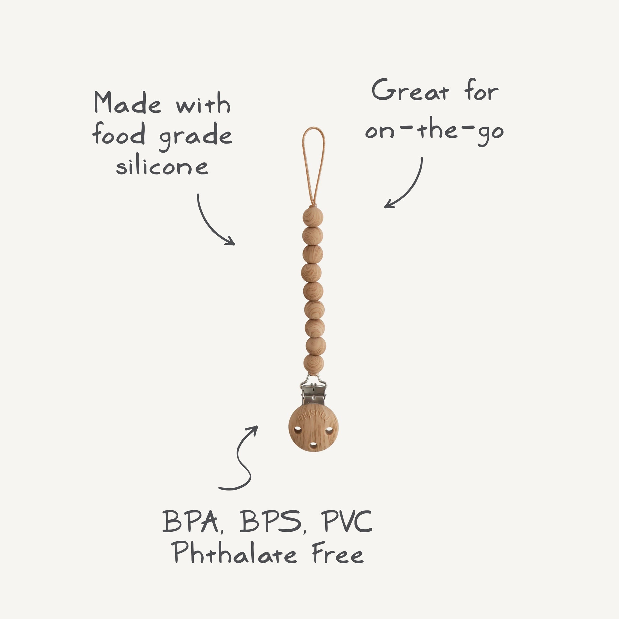 The mushie Silicone Pacifier Clip | Hera features a minimalist design with food-grade silicone beads and a wooden clasp. Free of BPA, BPS, PVC, and phthalates—ideal for on-the-go use.