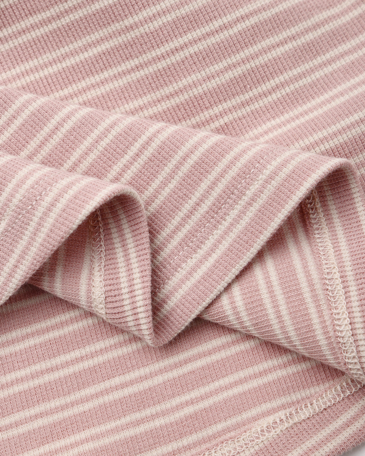 Closeup of Rylee + Cru Ribbed Long Sleeve Dress in dusty rose microstripe with white stripes.