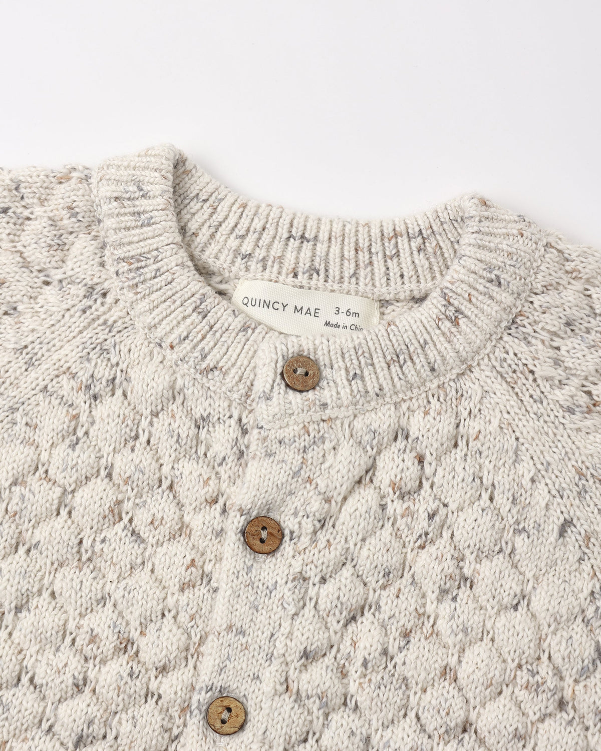 Close-up of a Bubble Knit Cardigan Natural Confetti by Rylee + Cru with wooden buttons.