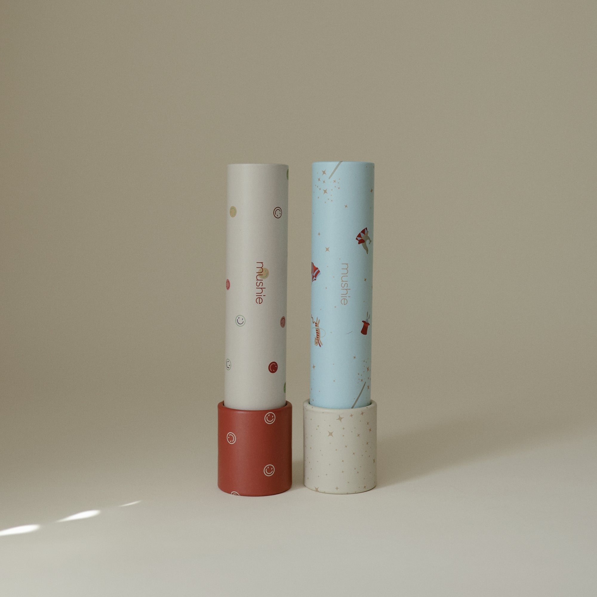 Two mushie Kaleidoscopes with playful patterns stand upright, inviting creative exploration.
