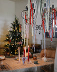 Festive table with candles, ribbons, and mushie Silicone Baby Food Containers for daycare snacks.