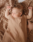 Lifestyle picture of a Mushie Sleep Bag in Natural on a baby.